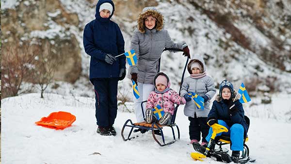 scandinavian-family-with-sweden-flag-in-winter-swe-2022-01-19-18-14-34-utcz